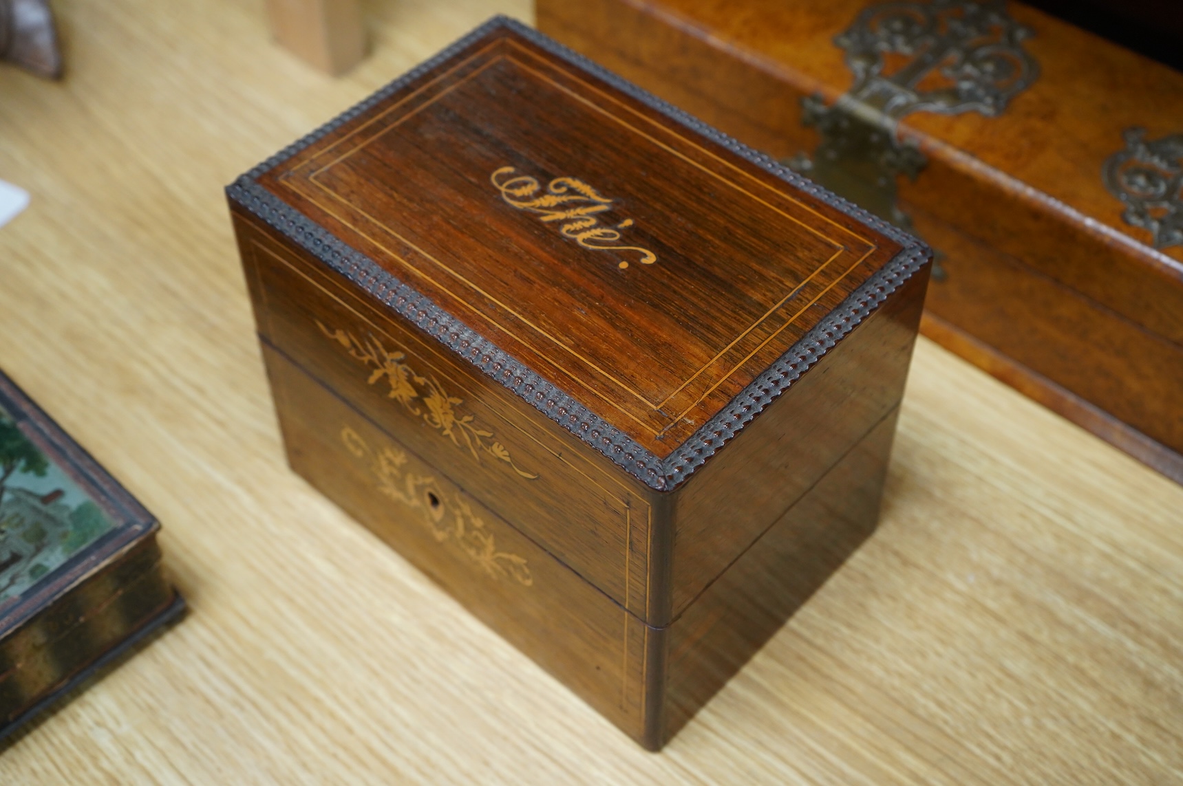 Four boxes to include a burr elm bound example, together with a French inlaid ‘Thé’ caddy with porcelain canisters, largest 32cm wide